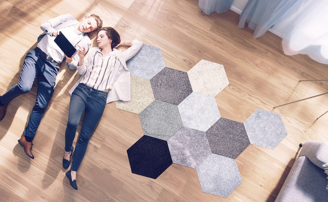 Couple on the floor with carpet tiles besides them